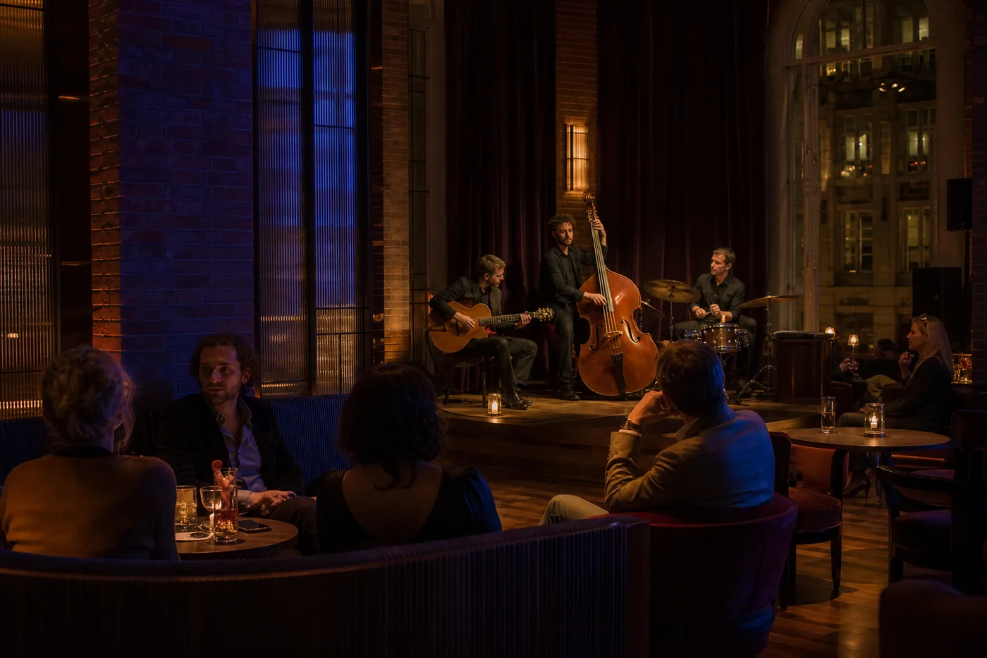 Late hotellounge met kleine muziekplek, baksteen en zittende gasten